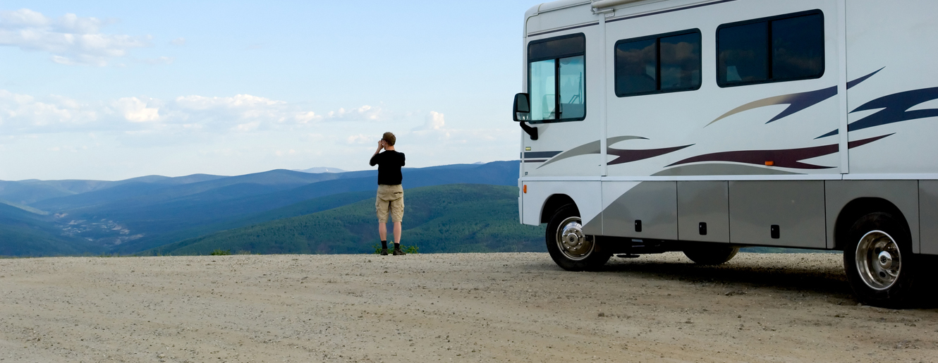 Man viewing mountains outside of his RV Camper.
